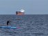 Scott paddleboarding by a ship